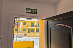 A door with a sign reading 'SALIDA' and a view of a yellow building outside.