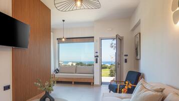 Departamento de diseñador, 2 habitaciones, vista al mar | Área de sala de estar | Smart TV de 43 pulgadas con canales vía satélite