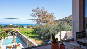 A balcony with a view of the sea, a pool, and a garden. - KaYa SeaView Residence (Mylopotamos)