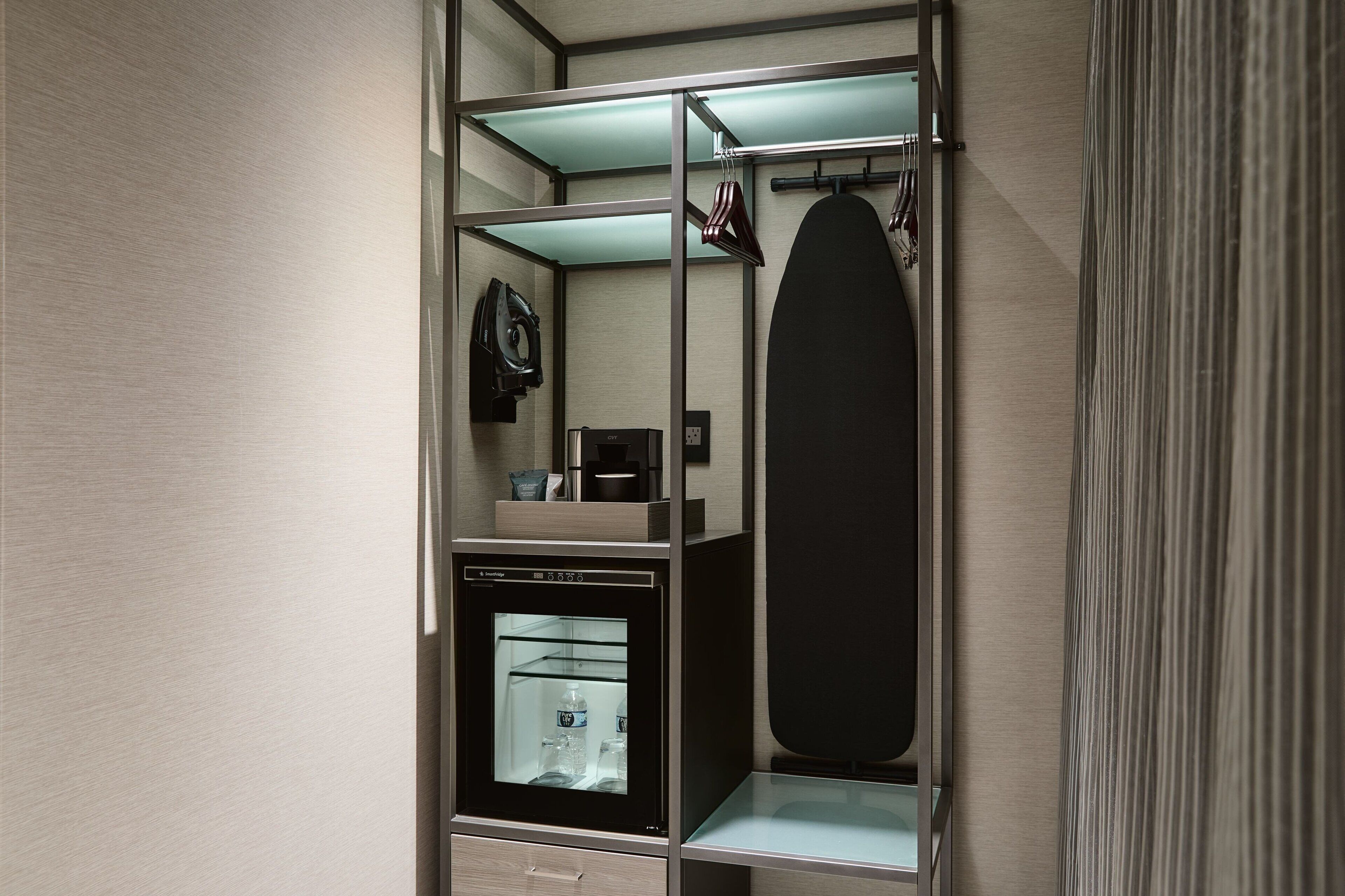 Un baño moderno y compacto con ducha integrada, un espejo y un perchero.