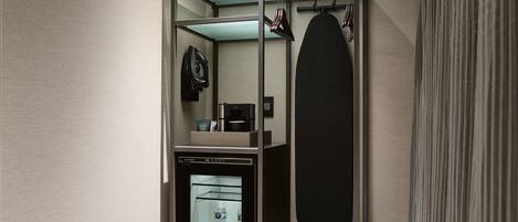 Un baño moderno y compacto con ducha integrada, un espejo y un perchero.