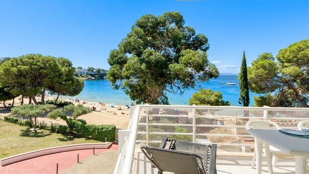 A terrace with a view of a beach and the sea, featuring a table and chairs. - RESIDENCIAL ALMADRAVA 4  Roses (Rosas / Roses)