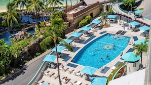 Ein Poolbereich eines Resorts mit mehreren Pools, Liegestühlen und Sonnenschirmen.