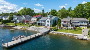 Une propriété située au bord de l’eau, dotée d’un quai, de maisons avec balcons et d’un petit abri de jardin.