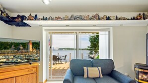 Un salon avec une grande télévision, un canapé bleu, un meuble en bois et une cheminée.