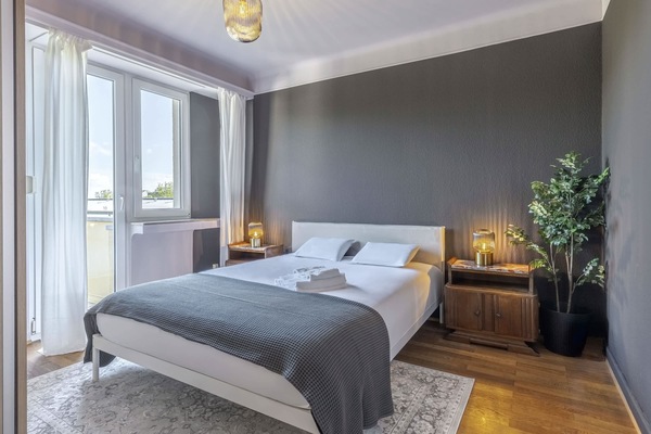 Elegant master bedroom featuring a comfortable queen-sized bed, modern decor, and access to a private balcony for a serene retreat.