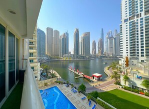 A high-rise building with a view of a marina and city skyline. - DreamLike Full Pool & Marina View (Dubai)