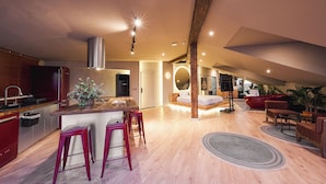 A modern kitchen with wooden countertops, red bar stools, and a central island. - Tare Houses Hotel (Istanbul)