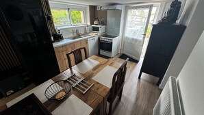 Cocina compacta con comedor, que incluye refrigerador, estufa, microondas y pileta.