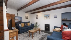 Ein Wohnzimmer mit einem blauen Sofa, einem Holztisch und einem Kamin.