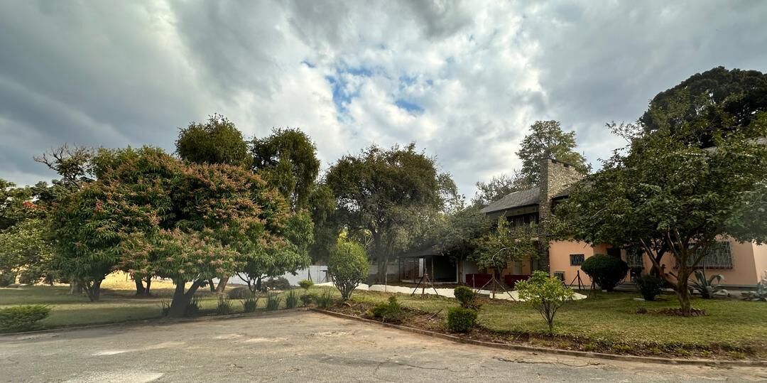 A residential area with a house, trees, and a clear sky.