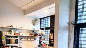 Une cuisine compacte dotée d’un îlot central, d’un four à micro-ondes et d’un réfrigérateur.