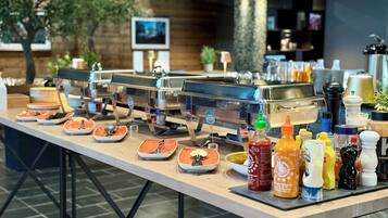A buffet setup with multiple self-service stations, a variety of condiments, and a coffee machine.