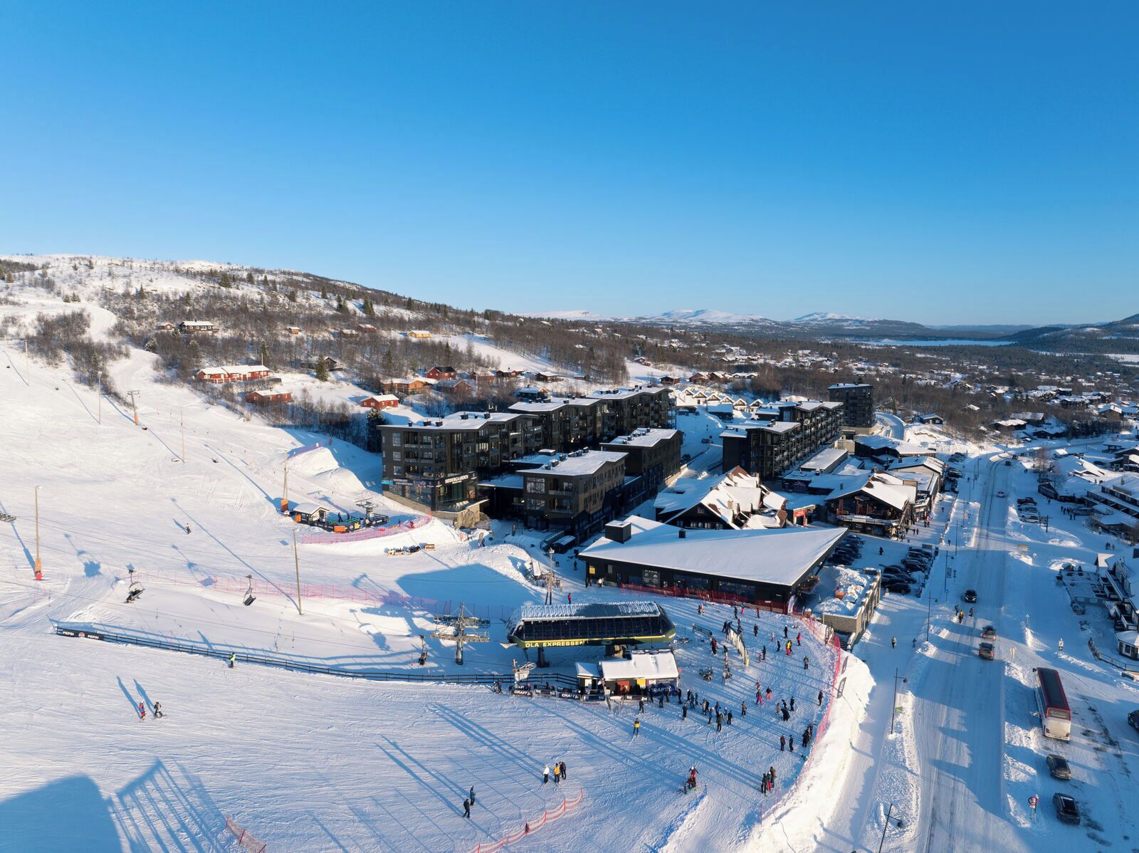 A ski resort with multiple buildings, ski lifts, and a snow-covered landscape.