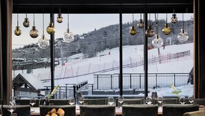 A restaurant with a view of a snowy mountain and ski slopes. - Riddergaarden Hotel & Mountain Lodge, Beitostølen (Øystre Slidre)
