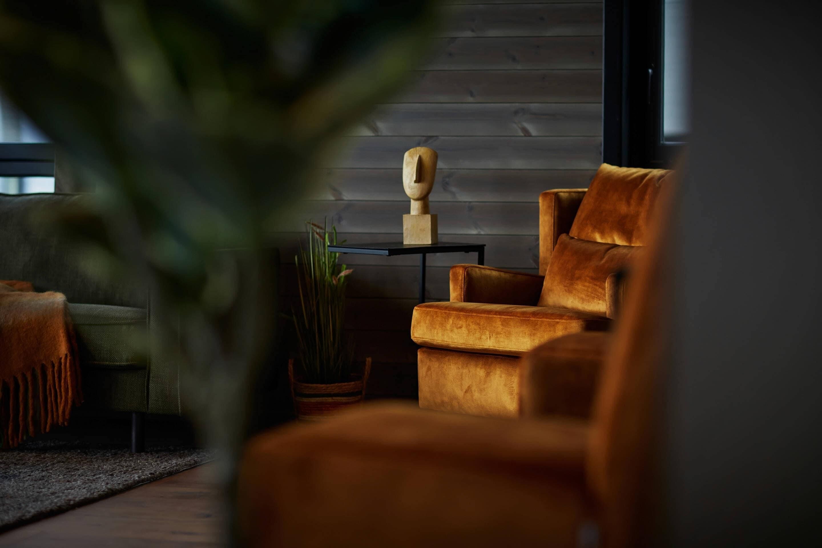 A modern living room with a sofa, a side table, and a potted plant.