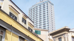 A tall hotel building with a modern facade and numerous windows. - La clè de la maison (Naples)