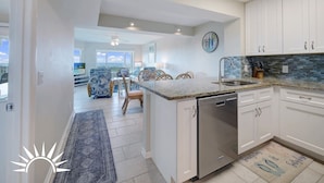 A modern kitchen with white cabinets, a granite countertop, and a dishwasher. - Colony Reef Club 1203 - 3 Bedroom Oceanfront, 2nd floor with elevator access (St. Augustine Beach)