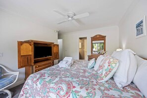 A hotel room with a bed, a wooden TV stand, a ceiling fan, and a view of the outdoors. - Fresh & Modern Villa by the Sea Beach Club Getaway (Hilton Head Island)