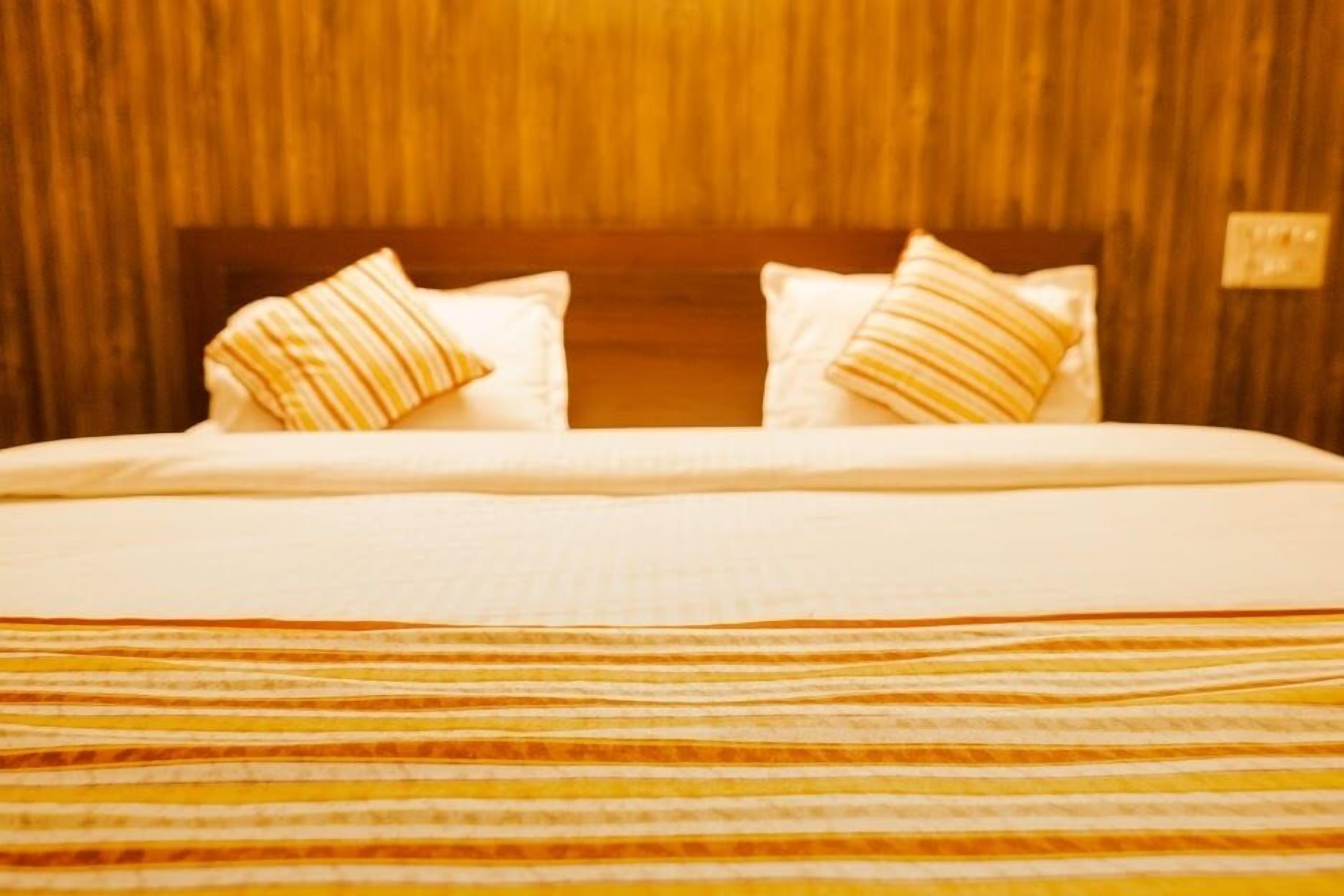 A bed with striped bedding and two pillows with striped patterns.