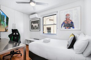 Relax in a serene space with a comfortable bed, desk, and large window.