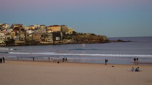 Une ville côtière avec des bâtiments le long de la plage et une plage où se trouvent des gens.