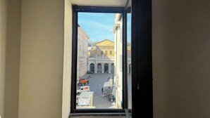 Uitzicht vanuit een raam op een straat en gebouwen.