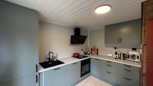 A compact kitchen with a built-in oven, a microwave, and a coffee maker.