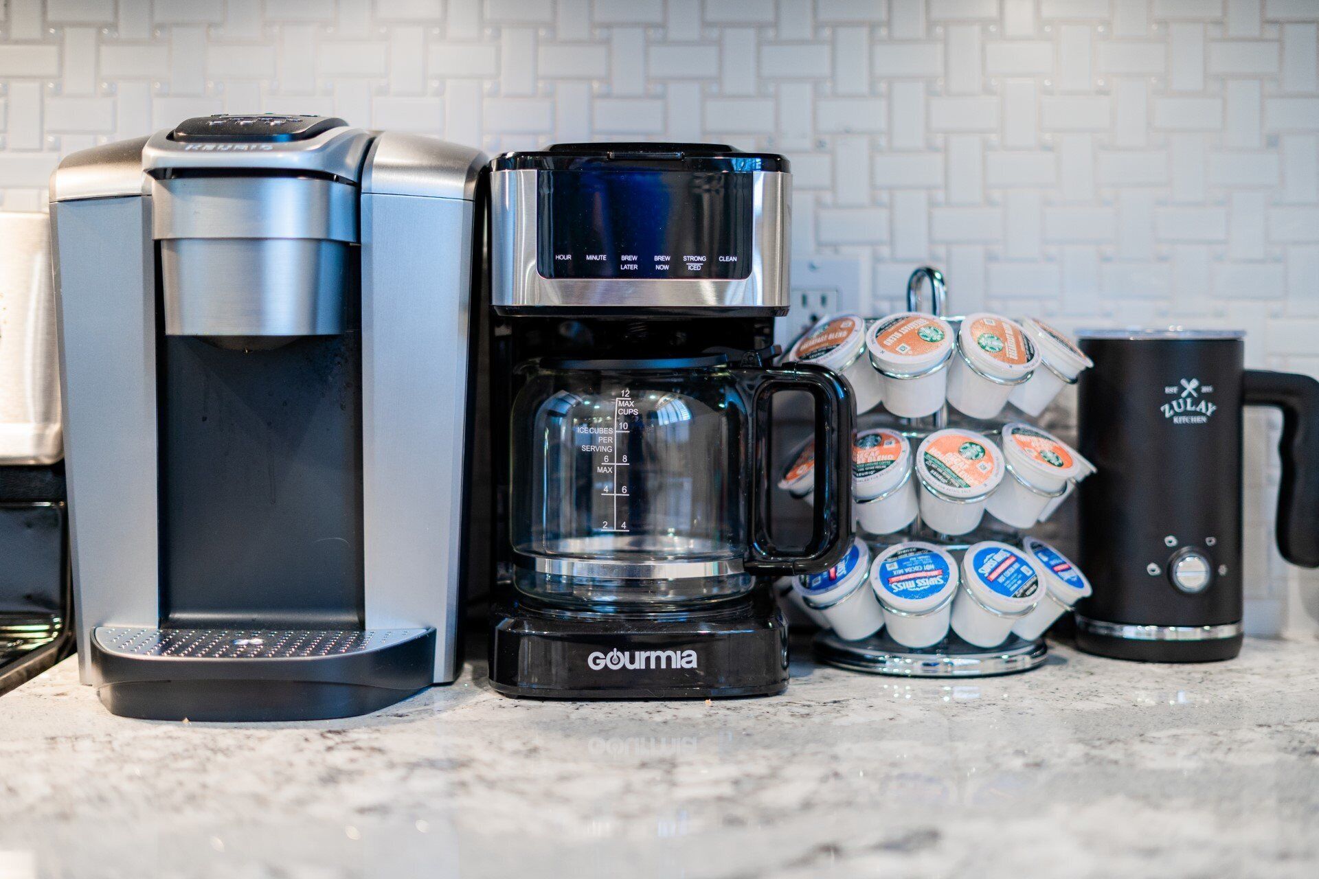 Une machine à café, une balance et une tasse sur un plan de travail de cuisine.