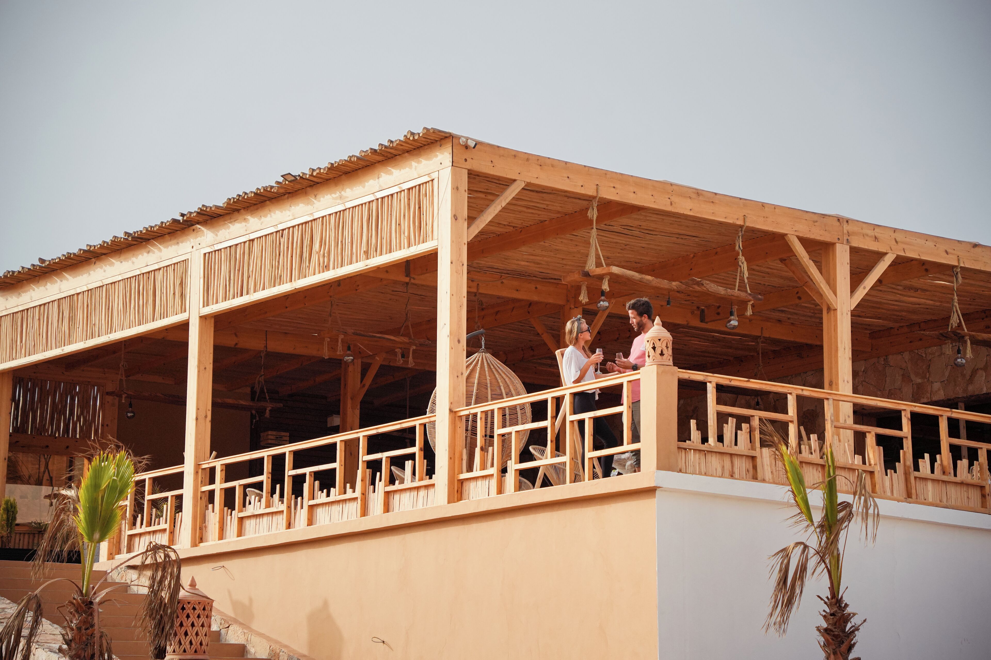 A wooden structure with a balcony, featuring a simple design and open space.