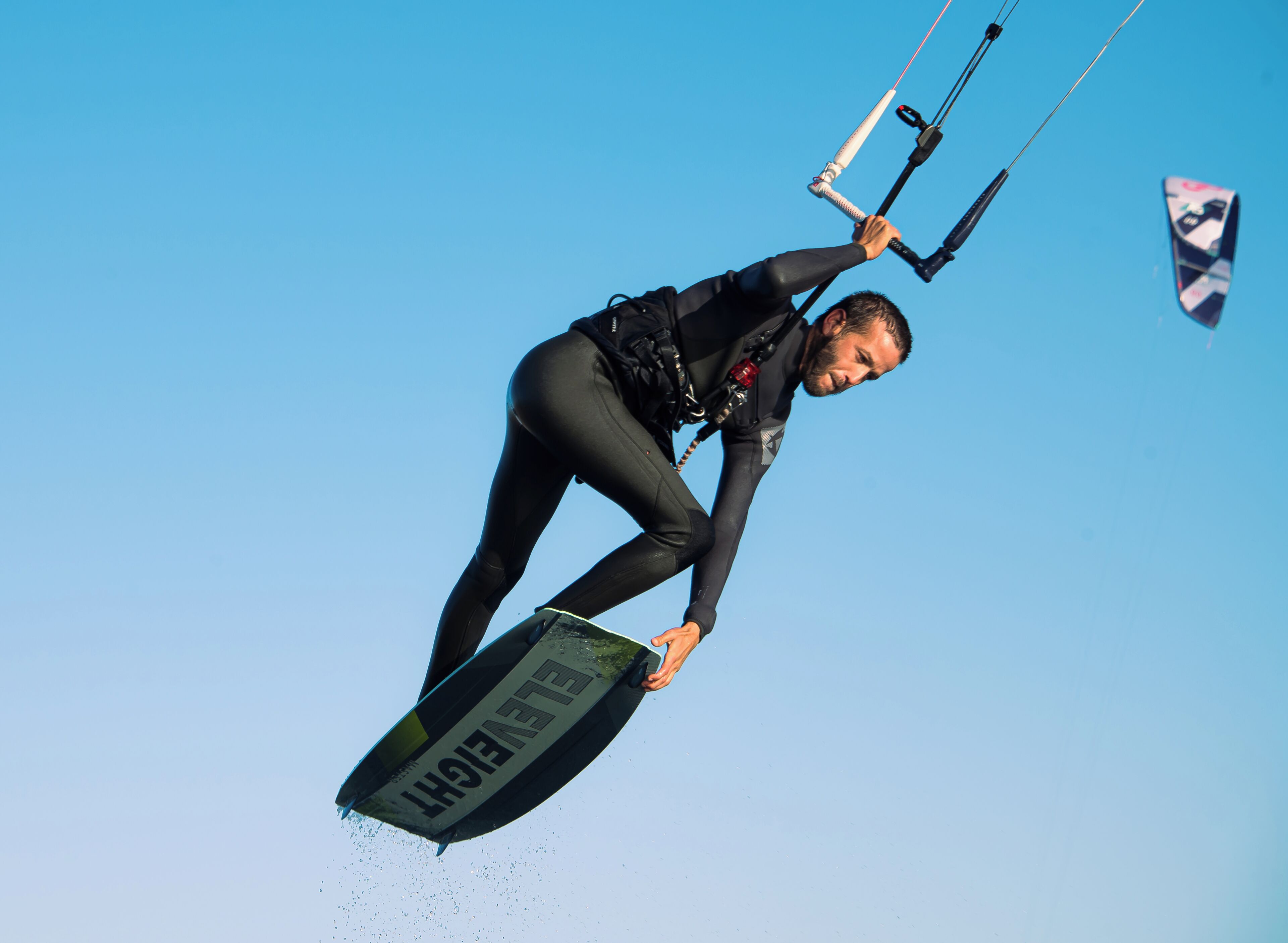 A person kiteboarding in clear blue skies.