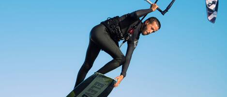 A person kiteboarding in clear blue skies.
