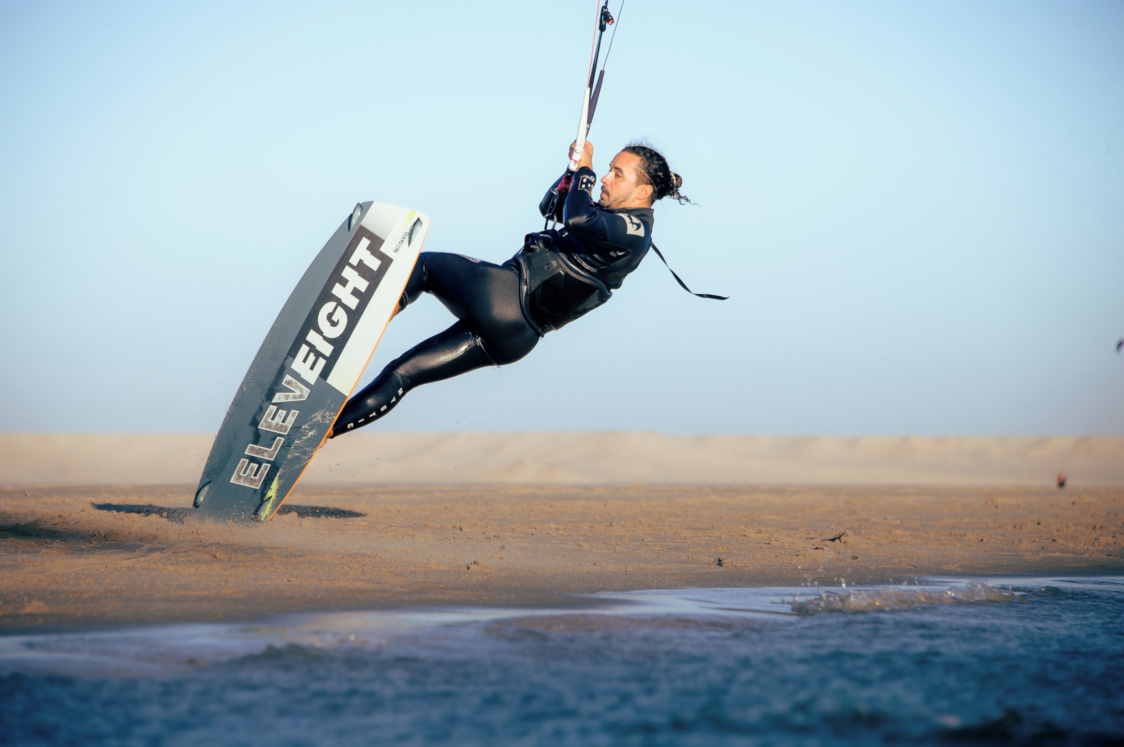 A person kiteboarding on a beach.