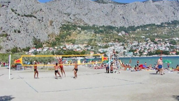 A beach volleyball court with players, a net, and spectators. - Cozy 2-bedroom apartment in small place Ostrvica near Omiš (Ostrvica)