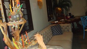 A living room with a tufted sofa, a decorative tree sculpture, and a wall-mounted light fixture. - Lost town Inn Hotel (Antalya)