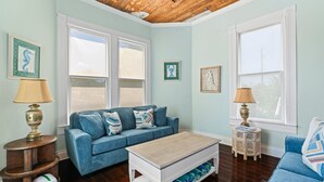 Un salon avec un canapé bleu, une table basse en bois et deux lampes.