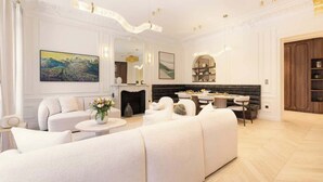 A spacious living room with a fireplace, white sofas, a dining area, and a bookshelf. - Exceptional 3BR/3BA w/ Services - Champs-Elysées (Paris)