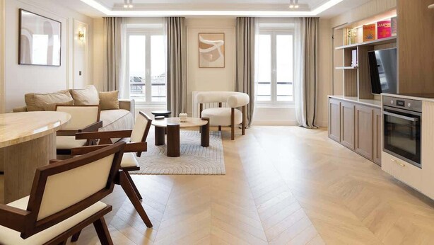 A modern living room with a dining area, a kitchen, and a large window providing natural light. - A Splendid 2-BR/2BA with Services in Opéra (Paris)