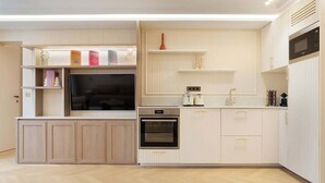 A modern kitchen with built-in appliances, wooden cabinets, and a herringbone floor pattern. - A Splendid 2-BR/2BA with Services in Opéra (Paris)
