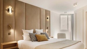 A modern bedroom with a large bed, a nightstand, and wall-mounted lighting. - A Splendid 2-BR/2BA with Services in Opéra (Paris)
