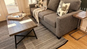 Un salon avec un canapé, une table basse et un tapis.