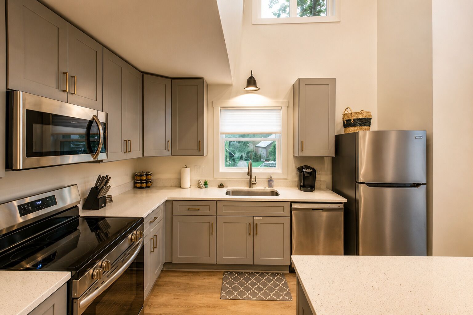 A modern kitchen with stainless steel appliances, a window, and a view of the outdoors.
