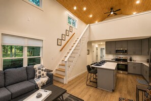 A modern interior with a staircase, a kitchen, and a living area.