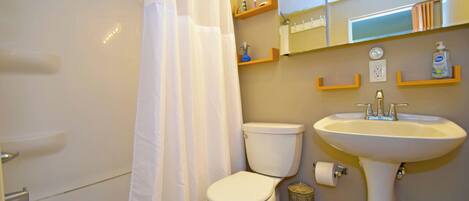 A bathroom with a bathtub, toilet, sink, and shower curtain.