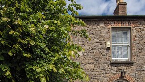 A stone building with a yellow door and a window with a white frame. - Linden House/Slane/Near NewGrange (Slane)
