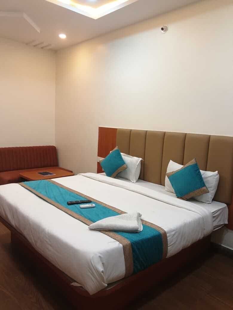 Una habitación de hotel con cama, mesita de noche y zona de estar.