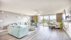A spacious living room with a sectional sofa, a coffee table, and a dining area with chairs. - 3203 Yacht Club Villas (North Myrtle Beach)