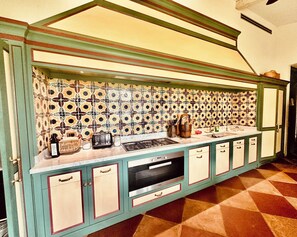 A kitchen with a patterned backsplash, a stove, and cabinets. - Maniero in Maremma, luxury villa  in Tuscany (Montiano)
