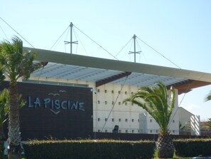 A building with a sign reading 'LA PISCINE' and a large overhang structure.