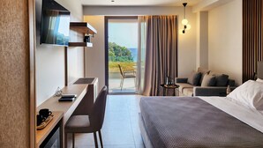 A hotel room with a bed, a desk, a chair, a TV, and a view of the outdoors. - Arete Lifestyle Hotel (Igoumenitsa)